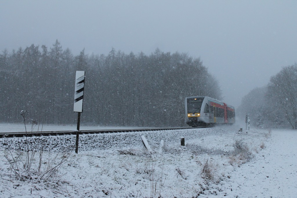 Im Schneetreiben am 24.01.2014 passiert ein GTW 2/6 der HLB den ehemaligen Bahnübergang zwischen Lich und Langsdorf auf der Lahn-Kinzig-Bahn.