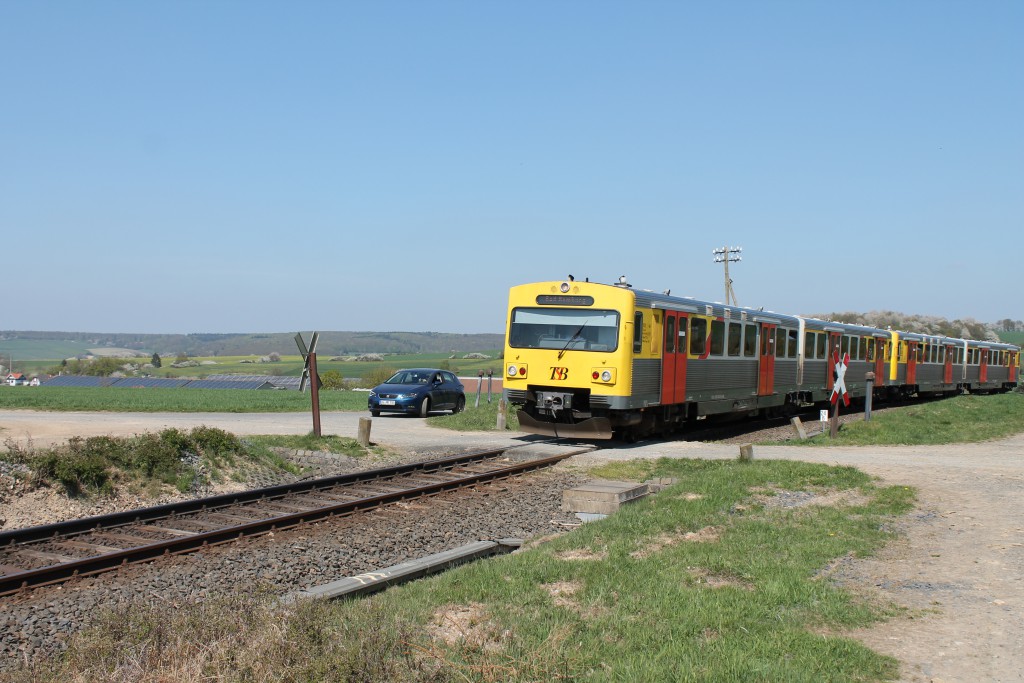 Eine Doppeltraktion VT2E der HLB überquert einen unbeschrankten Bahnübergang bei Hundstadt auf der Taunusbahn am 23.04.2015.