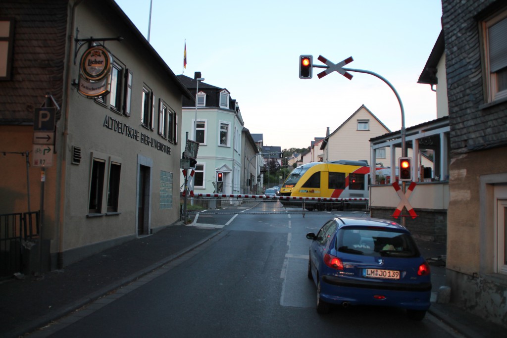 Nach einem Halt in Runkel überquert ein LINT der HLB am 01.08.2015 den Bahnübergang der Lahntalbahn.