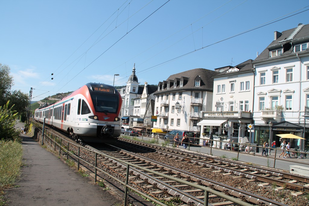 Ganz in weiß, mutet der Nahverkehr in Rüdesheim an. Am 30.08.2015 durchquert die VIAS mit einem FLIRT den Weinort in Richtung Frankfurt.