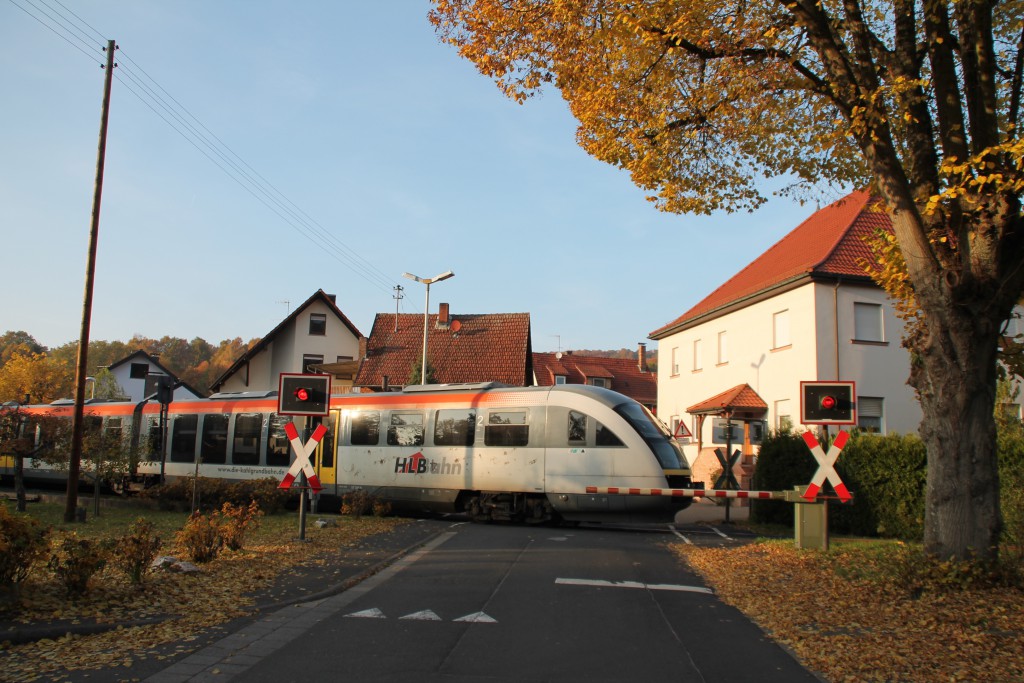 642 406 der HLB überquert am 31.10.2015 den Bahnübergang in Königshofen auf der Kahlgrundbahn.