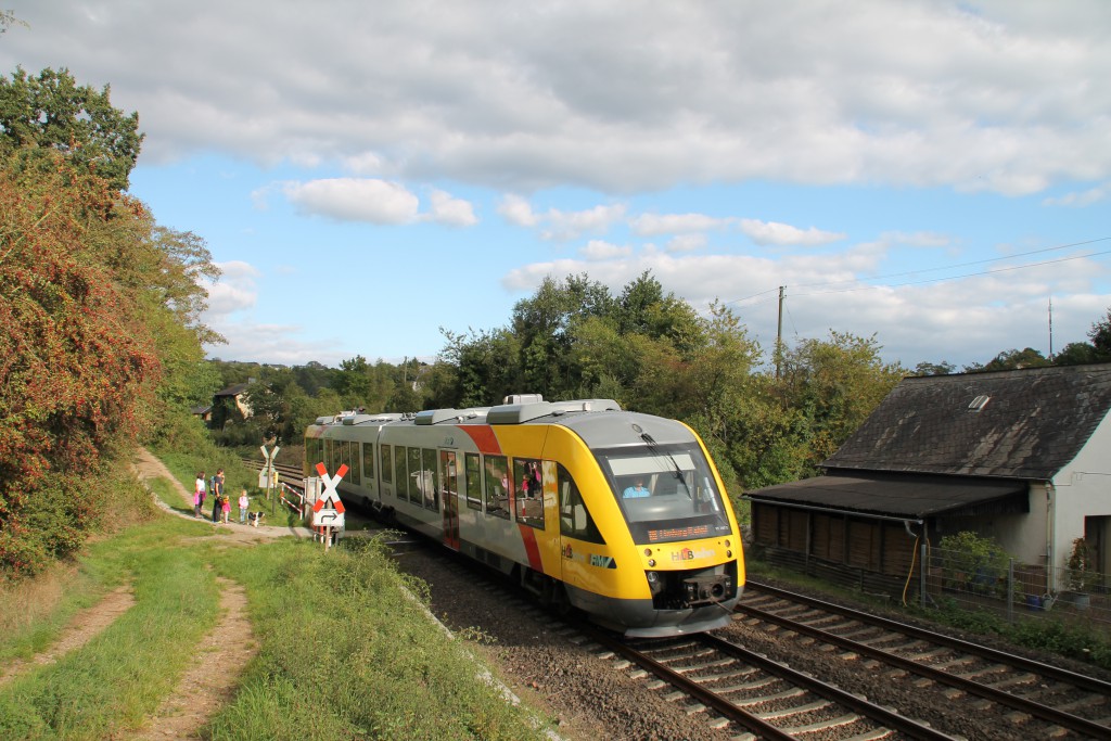 An der Anrufschranke in Villmar wartet eine Familie auf die Vorbeifahrt eines LINT der HLB, aufgenommen am 27.09.2015.