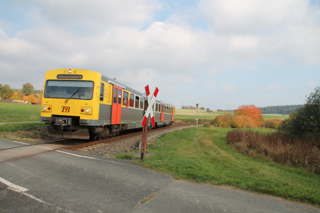 Ein VT2E der HLB ist auf dem Weg nach Grävenwiesbach, soeben hat er einen unbeschrankten Bahnübergang bei Hundstadt erreicht, aufgenommen am 10.10.2015.