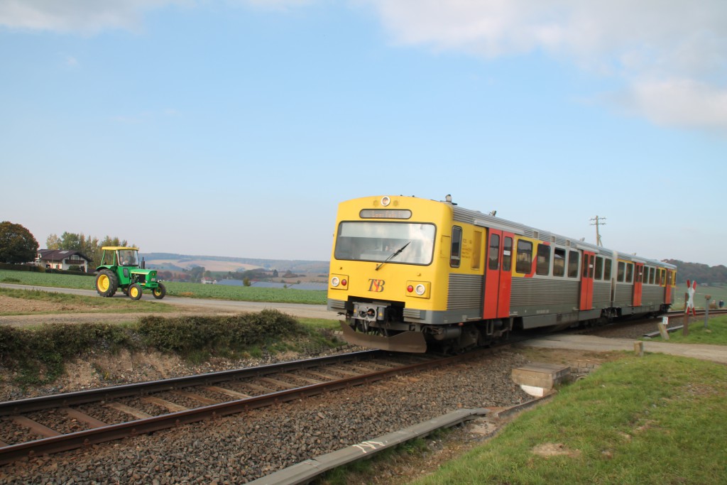 Ein Traktor wartet an einem unbeschrankten Bahnübergang bei Hundstadt auf diesen VT2E der HLB, aufgenommen am 10.10.2015.