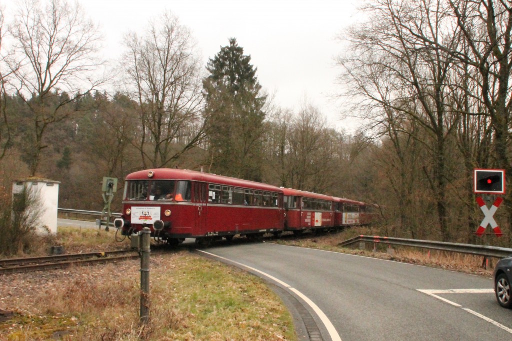 998 880, 998 250, 798 818, 798 622 und 796 724 auf einem Bahnübergang bei Seifen auf der Holzbachtalbahn, aufgenommen am 06.03.2016.