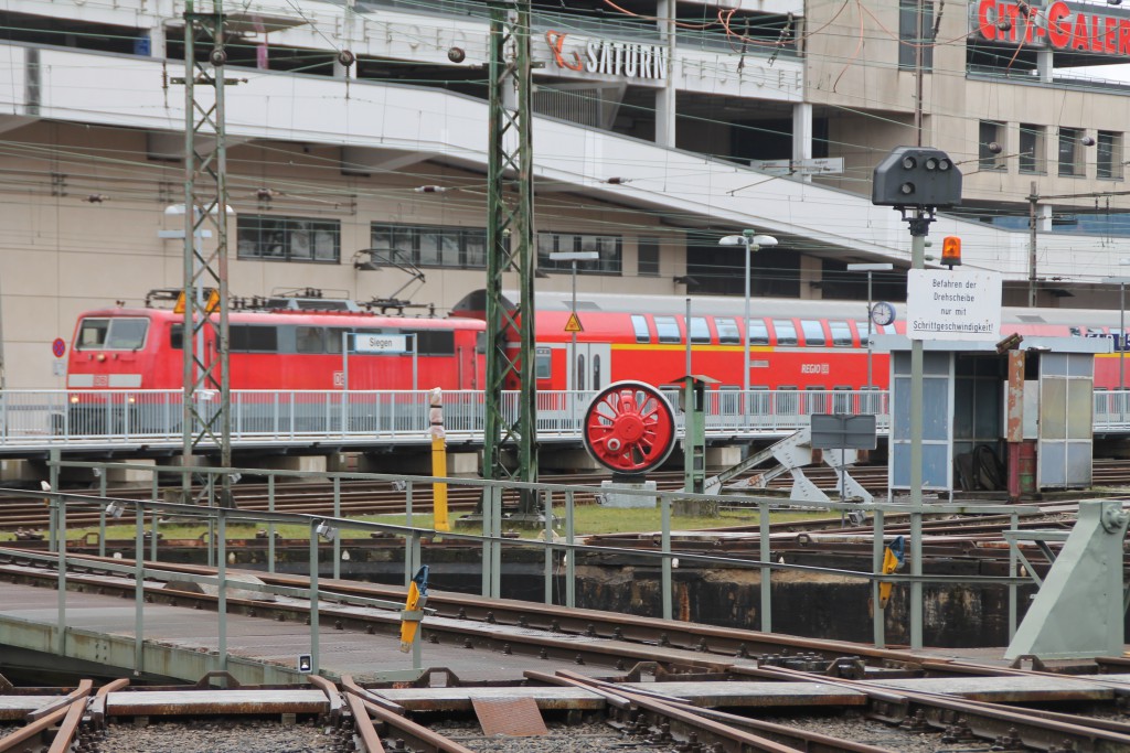 Hinter der Siegener Drehscheibe erreicht eine 111 mit ihrem Zug aus Doppelstockwagen den Bahnhof Siegen, aufgenommen am 27.03.2016.