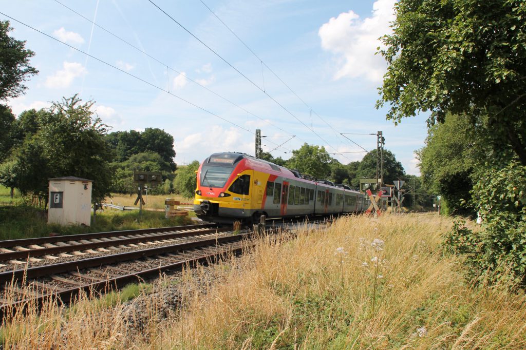 Ein FLIRT der HLB überquert den Bahnübergang bei Dillheim auf der Dillstrecke, aufgenommen am 06.07.2016.