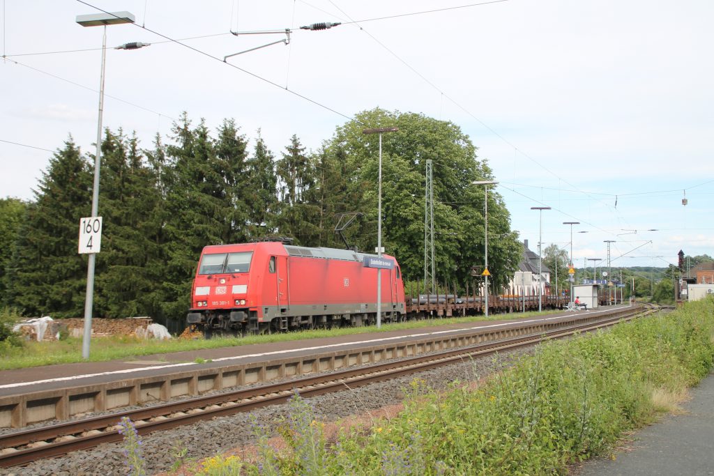 185 381 jagt mit ihrem Güterzug durch den Bahnhof Dutenhofen auf der Dillstrecke, aufgenommen am 29.06.2016.