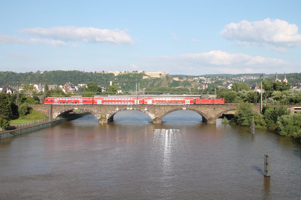 Eine 143 überquert mit ihren Doppelstockwagen die gemauerte Moselbrücke in Koblenz auf der linken Rheinstrecke, aufgenommen am 19.06.2016.