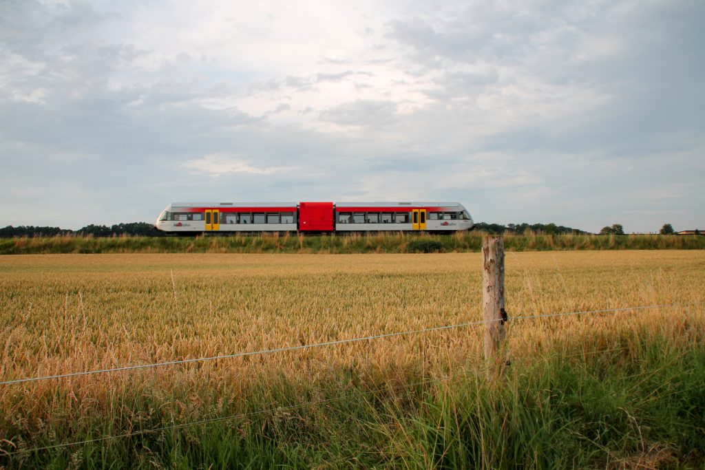 Ein GTW der HLB durchquert im Abendlicht die Felder bei Hungen auf der Lahn-Kinzig-Bahn, aufgenommen am 10.07.2016.