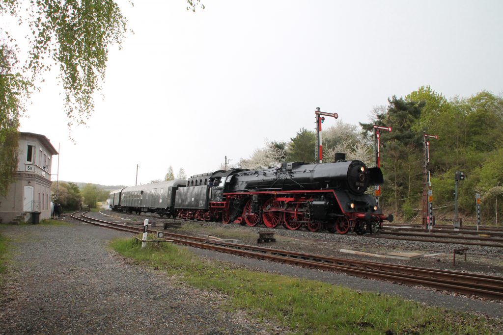 03 1010 fährt neben dem Stellwerk Sn in den Bahnhof Glauburg-Stockheim ein, aufgenommen am 24.04.2016.