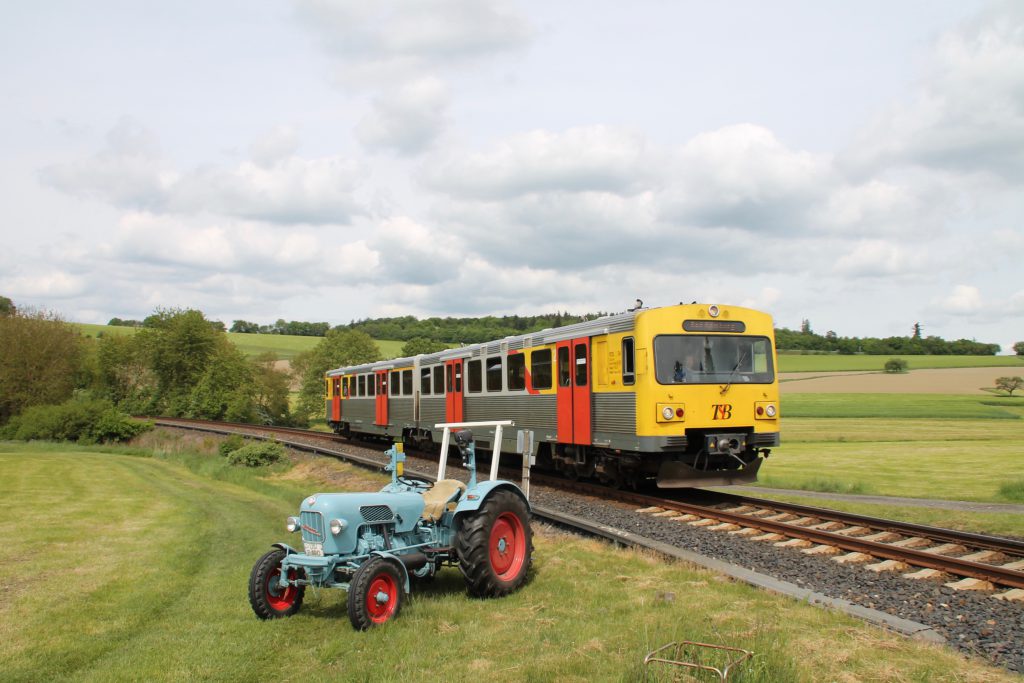 Ein VT2E der HLB begegnet einem Eicher Traktor in Hundstadt auf der Taunusbahn, aufgenommen am 21.05.2016.