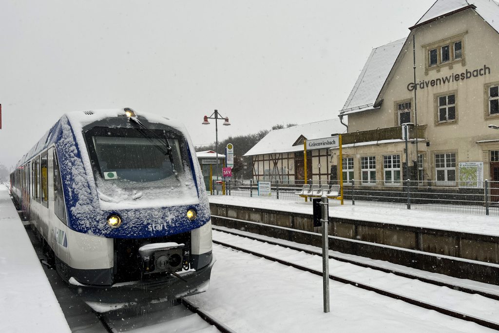 554 126 steht am Bahnsteig im verschneiten Grävenwiesbach auf der Taunusbahn, aufgenommen am 18.01.2024.