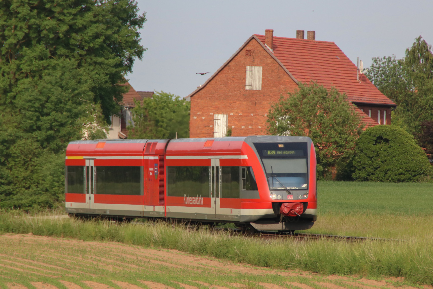 646 211 an einem Backsteinhaus bei Mandern auf der Bahnstrecke Wabern - Bad Wildungen, aufgenommen am 28.05.2017.