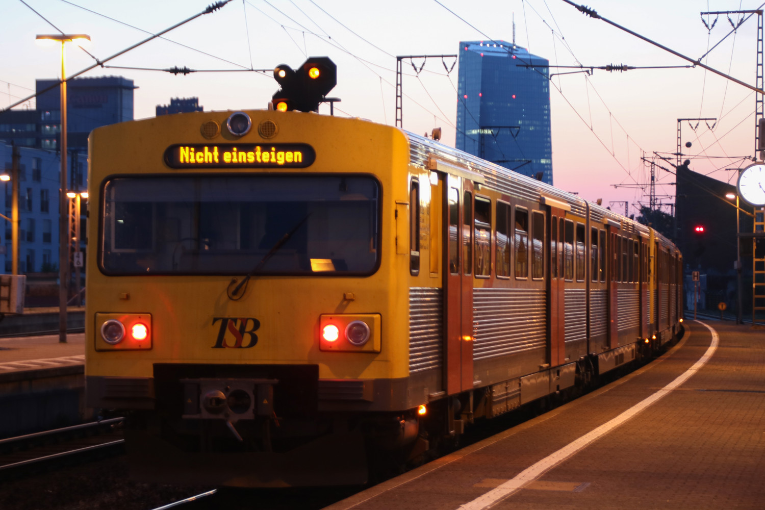 Drei VT2E der HLB stehen in der Morgendämmerung im Bahnhof Frankfurt-Süd, im Hintergrund die Europäische Zentralbank, aufgenommen am 19.07.2017.