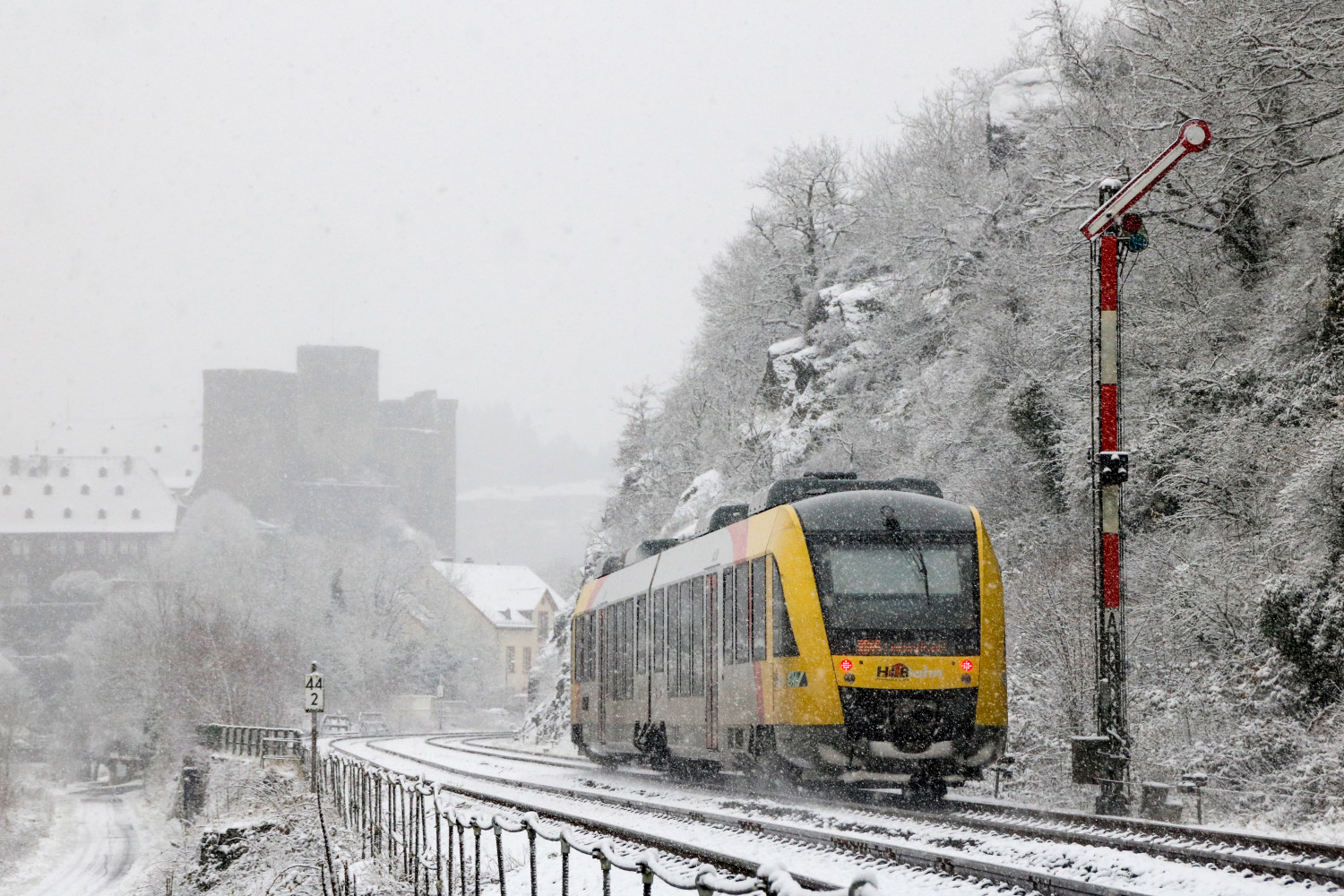 Ein LINT der HLB am Blocksignal von Runkel auf der verschneiten Lahntalbahn, aufgenommen am 03.12.2017.