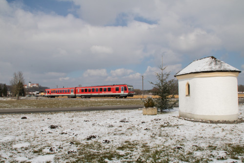 628 584 an einer Kapelle bei Altenmark auf der Traun-Alz-Bahn, im Hintergrund ist das Kloster Baumburg, aufgenommen am 20.03.2018.