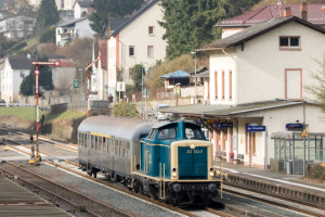 212 372 mit einem Silberling vor dem Bahnhofsgebäude in Löhnberg auf der Lahntalbahn, aufgenommen am 24.03.2018.
