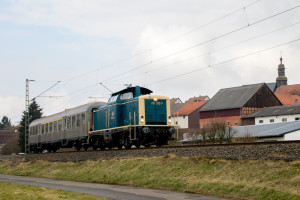 212 372 mit einem Silberling vor der Dorfkulisse von Anzefahr auf der Main-Weser-Bahn, aufgenommen am 24.03.2018.