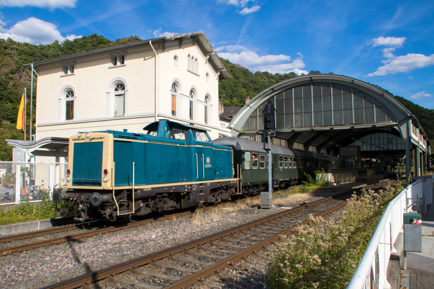 212 372 verlässt die kleinste Bahnhofshalle in Deutschland, aufgenommen am 11.08.2018 in Bad Ems auf der Lahntalbahn.