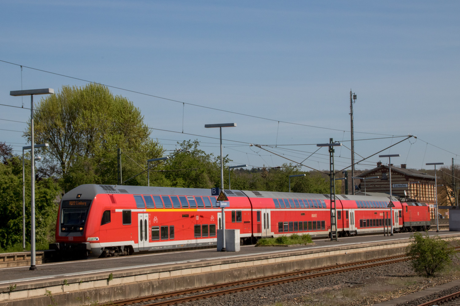 Eine 143 mit steht mit ihren Doppelstockwagen in Eschhofen auf der Lahntalbahn, aufgenommen am 22.04.2019.