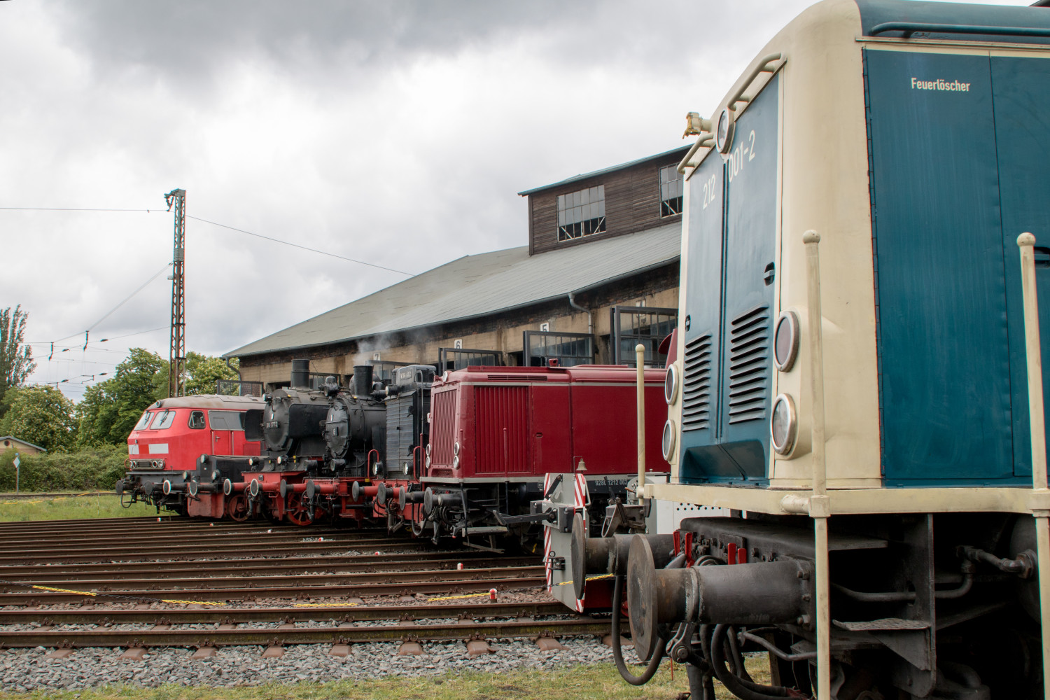 225 133, 212 062 sowie einige Dampfloks stehen im Lokschuppen des Bahnbetriebswerkes in Hanau, im Vordergrund steht 212 001, aufgenommen am 04.05.2019.