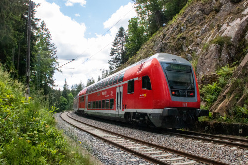 Ein Zug aus Doppelstockwagen durchquert den Wald bei Triberg auf der Schwarzwaldbahn, aufgenommen am 25.05.2022.