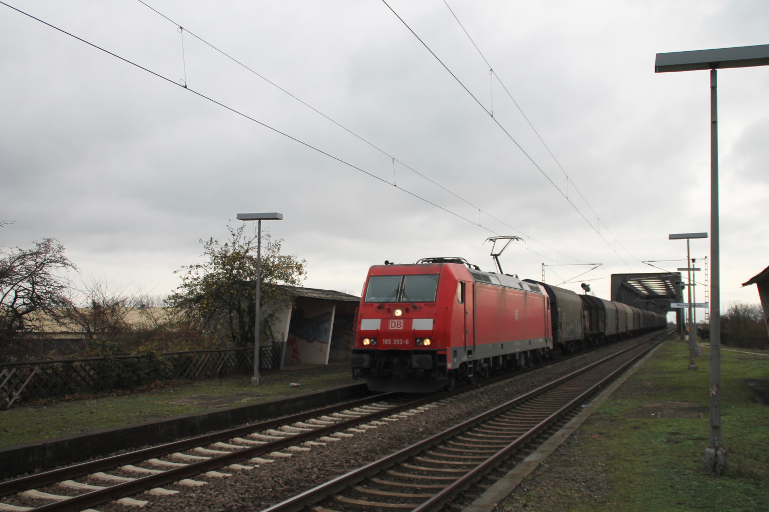 185 393 durchquert den stillgelegten Haltepunkt Worms-Brücke am 21.11.2015.